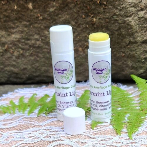 Close up of 2 peppermint hemp lip balms, one with the cap off and the balm turned up to be visible