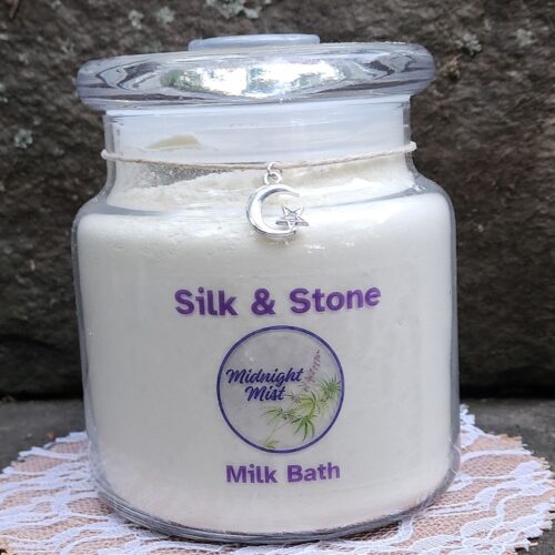 Close up of Silk & Stone milk bath jar with moon charm