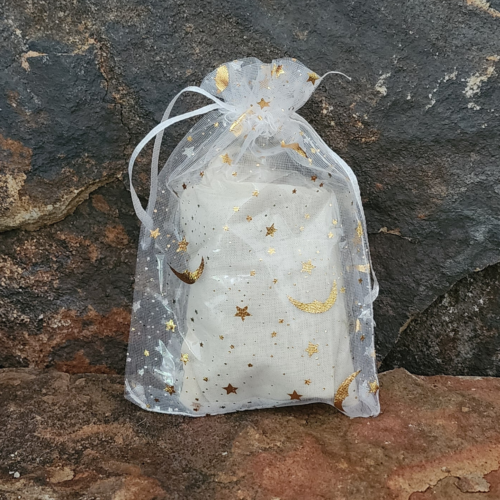 Closeup of mint filled sachet with white organza bag on stone background