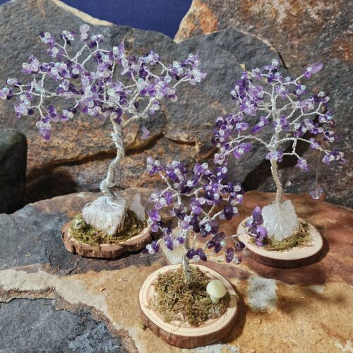 Handcrafted silver wire and amethyst gemstone Tree of Life in Sapling (small), Woodland (medium), and Ancient (large) sizes on natural wood bases with natural moss and stone mushrooms.