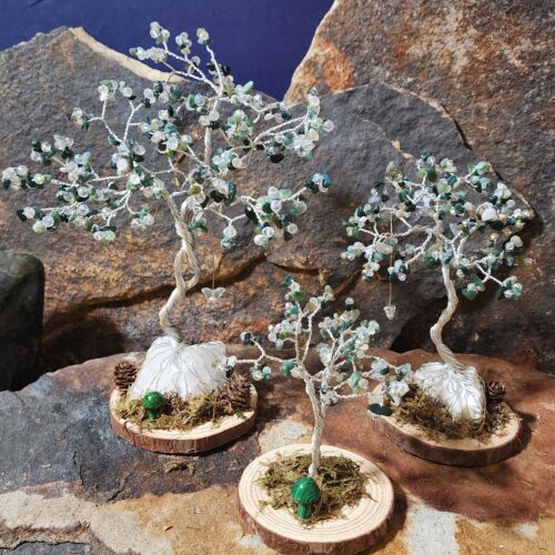 Handcrafted silver wire and moss agate gemstone Tree of Life in Sapling (small), Woodland (medium), and Ancient (large) sizes on natural wood bases with natural moss and stone mushrooms.