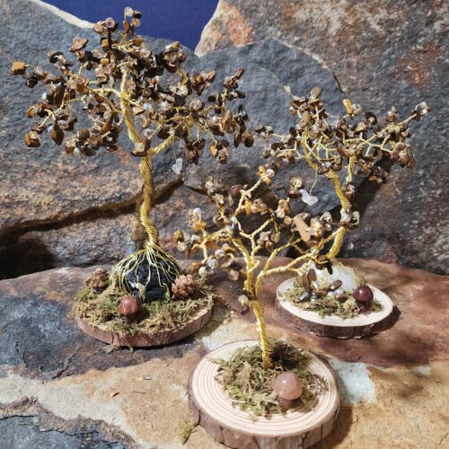 Handcrafted gold wire and tiger eye gemstone Tree of Life in Sapling (small), Woodland (medium), and Ancient (large) sizes on natural wood bases with natural moss and stone mushrooms.